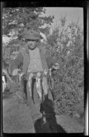H. H. West posing with trout, Mammoth Lakes vicinity, about 1922