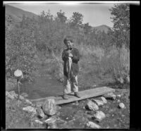 Chester Schmitz posing with fish, June Lake vicinity, 1914