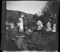 Mary A. West, Elizabeth West, Chester Schmitz, Frances West and Irene Schmitz standing around the camp, June Lake vicinity, 1914
