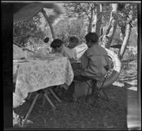 Chester Schmitz, Irene Schmitz and Elizabeth West sitting in the campsite, June Lake vicinity, 1914