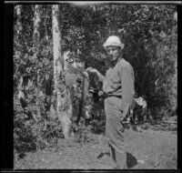 Howard Buttress posing with a fish in camp, June Lake vicinity, 1914