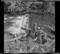 Mary A. West, Kate A. Schmitz, Irene Schmitz, Albert Schmitz and Chester Schmitz looking at pool at the base of a waterfall, June Lake vicinity, 1914