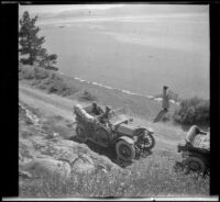 View from a bluff looking down on Nella West, Mary A. West and Isabelle Smith stopped along the shore of Lake Tahoe, Lake Tahoe, 1913