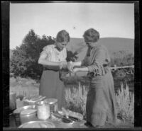 Isabelle Smith and Nella West cleaning trout in camp, Carson City vicinity, 1913