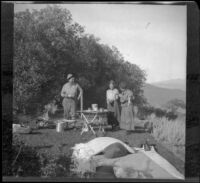 Dave F. Smith, Isabelle Smith and Nella West standing around the camp dining table, Carson City vicinity, 1913