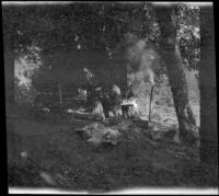 Mary A. West and Dave F. Smith standing at a table in camp at Silver Lake, June Lake vicinity, 1913