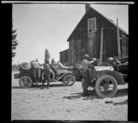 Men milling about their cars parked outside the general store in Mono Mills, Mono Lake, 1913