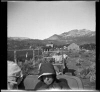 Nella West, Dave F. Smith and Isabelle Smith riding in their cars as they leave Mammoth, Mammoth Lakes, 1913