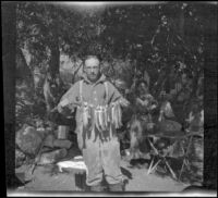 H. H. West posing with the limit of golden trout in camp, Inyo County, 1913
