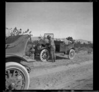 Dave F. Smith fixing his car by the roadside, Rosamond (vicinity), 1913