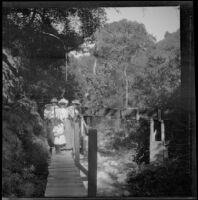 Glen and Bessie Velzy and Mary West and her daughters cross a wooden walkway behind Glen Ivy Hot Springs Hotel, Corona, 1909