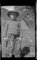 Ambrose Cline posing in front of the miner's tent, San Francisquito Canyon, about 1923