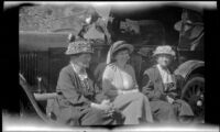 Christine Schmitz, Mary A. West and Minnie West sitting in a row on a car's running board, San Francisquito Canyon, [about 1917]