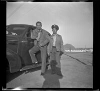 H. H. West Jr. leans on a car while Charles Glenn stands next to him, San Luis Obispo, 1942