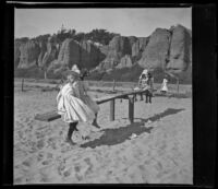 Girls play on a seesaw on the beach, Santa Monica, about 1895