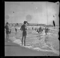 Men play in the surf with the pier in the background, Santa Monica, about 1895