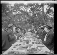 Attendees of the Rubber Men's Picnic dining at a long picnic table, Santa Monica Canyon, about 1908