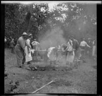 Game Warden Pritchard and others prepare barbecue at the Rubber Men's Picnic, Santa Monica Canyon, about 1908