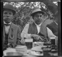 H. H. West and Mel Nordlinger sit and eat at the Rubber Men's Picnic, Santa Monica Canyon, about 1908
