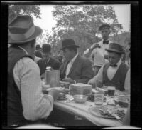 Webb Brain, Jim Jeffries and Bill Newerf eating at the Rubber Men's Picnic, Santa Monica Canyon, about 1908