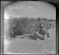Al Schmitz sits in the road and fishes a culvert of Taboose Creek, Big Pine vicinity, about 1917