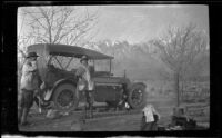 Elmer Cole and Al Schmitz stand by H. H. West's Cadillac in their camp near Taboose Creek, Big Pine vicinity, about 1920