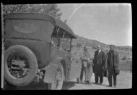 Al Schmitz, Charlie Stavnow and Elmer Cole stand beside the front end of H. H. West's Cadillac, Big Pine vicinity, about 1920