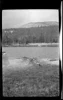 Al Schmitz and a campfire sit on the shore of Elizabeth Lake, Tuolumne Meadows, about 1922