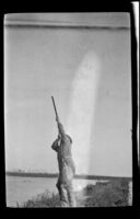Frank Mellus aims his gun into the air, Seal Beach vicinity, 1916