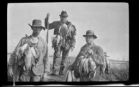 Keeper E. D. Hardy, Frank Mellus and John A. Hunter pose with strings of ducks, Seal Beach vicinity, 1916