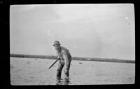 Glen Velzy picking up a dead duck out by the decoys, Seal Beach vicinity, 1917