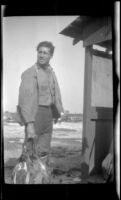 Walter Morosco carries a string of ducks, Seal Beach vicinity, 1920