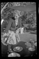 Mertie West stands at a camping stove at Rock Creek, Mammoth Lakes vicinity, 1940