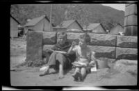 Ambrose Cline and H. H. West, Jr. sit down behind a concrete wall and eat a pie, Topanga, about 1922