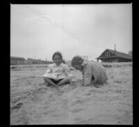 Elizabeth and Frances West sit in the sand, Venice, about 1910