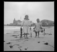 Elizabeth West and Frances West pose with kelp in front of Venice pier, Venice, about 1910