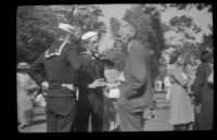 Two sailors speak with another man at the Iowa Picnic in Bixby Park, Long Beach, 1938
