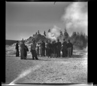 Tour group gathered around the cone of a geyser, Yellowstone National Park, 1942
