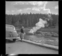 Mertie West watches Riverside Geyser erupt, Yellowstone National Park, 1942