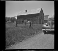 H. H. West poses in front of the old buildings at Klamath Junction, Ashland vicinity, 1942