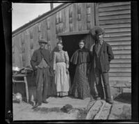 Charles Lemberger, Mary Lemberger, Carrie Hill and Silas Hill pose in front of a barn, Burlington, 1900