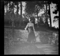 Mary West stands by a low stone wall in Elysian Park, Los Angeles, about 1904