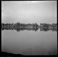Lake in MacArthur (Westlake) Park with trees and houses in the distance, Los Angeles, about 1898