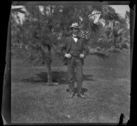 H. H. West stands in front of a tree in MacArthur (Westlake) Park, Los Angeles, about 1898