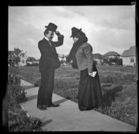 H. H. West and Daisy Kellum greet each other on a sidewalk, Los Angeles, about 1899