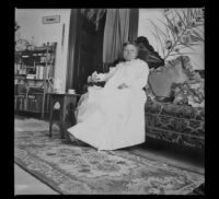 Lucretia Kellum poses on a sofa in her home, Los Angeles, about 1899