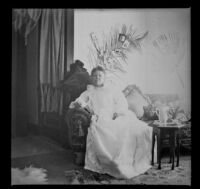Lucretia Kellum sits and poses on a sofa in her home, Los Angeles, about 1899