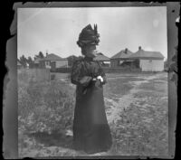 Lucretia Kellum stands outside, Los Angeles, about 1899