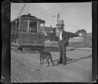 Guy West and his dog stand by a Los Angeles Railway car, Los Angeles, 1897
