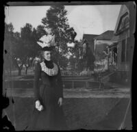 Louise Ambrose stands on the West's front lawn, Los Angeles, about 1899